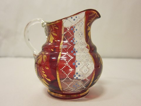 Glaskande / FlødekandeRød-og-hvid flødekande i glas med smuk emaljebemalingH: 9cmFra ca. 1890Vi har et stort udvalg af antikke glas